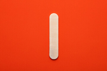 White wooden capital letter I on orange foamy background