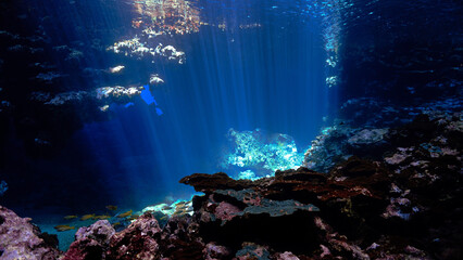 Underwater photo of rays of sunlight inside a cave