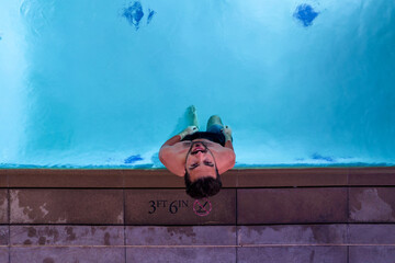 A man swimming in pool. Aerial view on person wich swim in swiming pool.