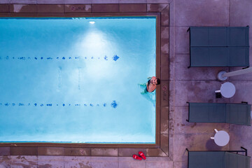 A man swimming in pool. Aerial view on person wich swim in swiming pool.