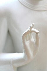 Hands of white stone Buddha in Buddhist temple