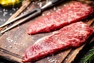 Raw steak with fork on the table. 