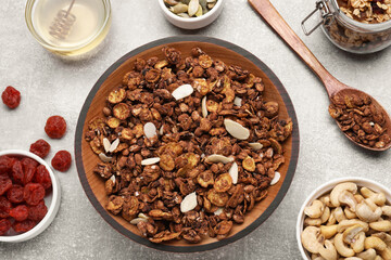 Tasty granola served with nuts and dry fruits on light grey table, flat lay