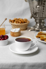 Fototapeta na wymiar Aromatic tea, traditional Russian samovar and treats on table