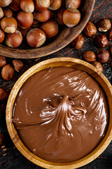 Hazelnut butter and inshell hazelnuts on the table in plates.