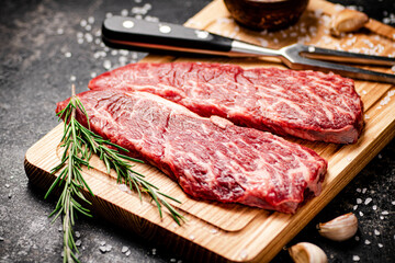 Raw steak on a wooden cutting board. 