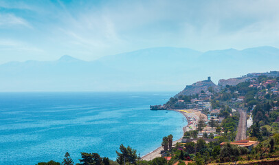 Azure Tyrrhenian sea bay and Rock of Capo Zafferano view from coastline highway road E90, Palermo region, Sicily, Italy. People are unrecognizable.