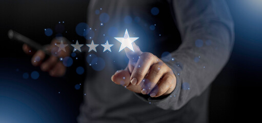 Satisfaction close up on customer man hand pressing on screen with five star rating feedback icon and press level excellent rank for giving best score point to review the service concept