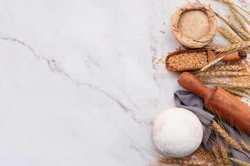 Wheat ears and wheat grains set up on marble background. Top view and copy space