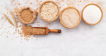  Wheat grains , brown wheat flour and white wheat flour in wooden bowl set up on white concrete background. - 564098959