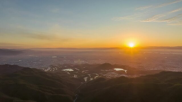 Time Lapse: Pan over sprawling city as sun rises over horizon and clouds move in