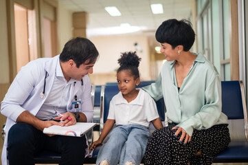 Pediatrician doctor examining child girl with her mother