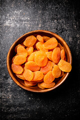 Delicious dried apricots in a wooden plate. 