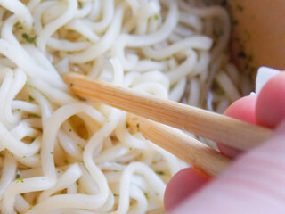 Delicious noodles with wooden sticks. Close-up