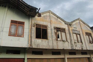 Fototapeta na wymiar damaged and abandoned old shophouse building