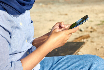 Close up photo of an Indonesian woman using a smartphone