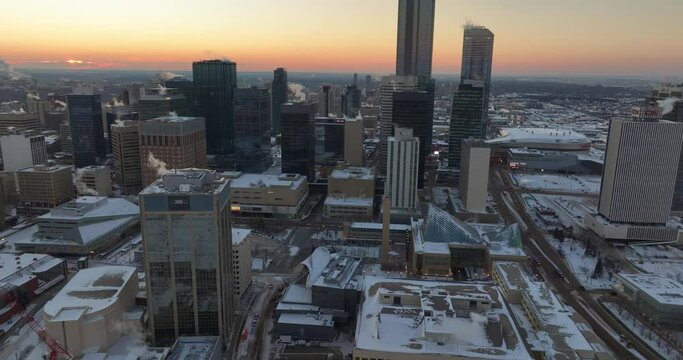 An aerial view of the high towers and skyscrapers in Edmonton, Alberta, with a winter sunset in the background
