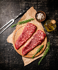 Raw steak on a wooden cutting board. 