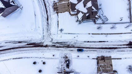 Aerial drone overhead view of a city street and plowed in residential driveway.