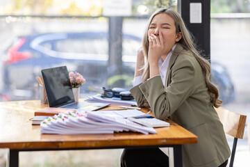 Bored Young business Asian woman sitting at her workplace at the office esk for a long time, Work mental health feel boring and Lazy, Freelance employees sleeping lying, Stress concept.