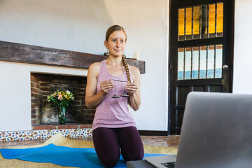 Caucasian woman smiling and starting yoga classes from home, wellness and mental health practice.