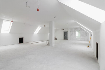 Spacious empty rooms in the attic floor after filling out the work on the wall and ceiling