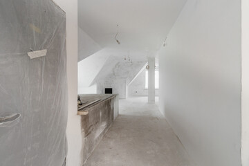 Spacious empty rooms in the attic floor after filling out the work on the wall and ceiling