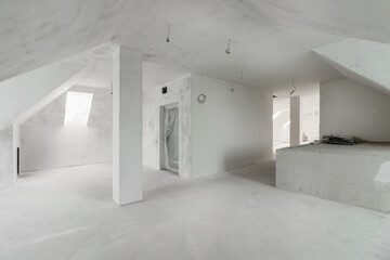 Spacious empty rooms in the attic floor after filling out the work on the wall and ceiling