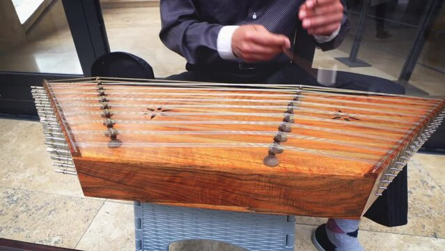 Street performer musician play dulcimer music instrument outdoors