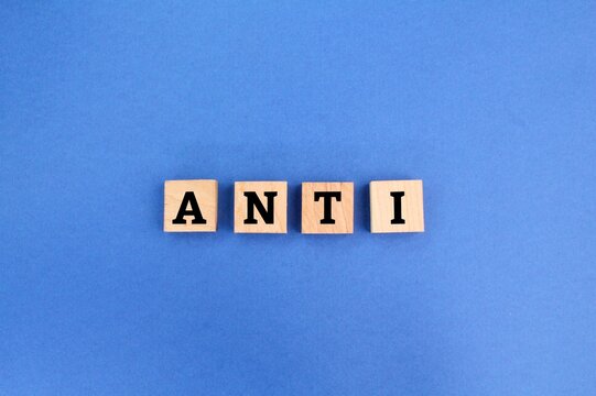 wooden cube with the word anti. the concept of opposition or anti. opposed to or against.