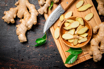 Chopped ginger on a cutting board with a knife. 