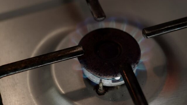 Top down close up view of old rusty gas stove, fire starts to burn. concept of cooking on gas stove in kitchen in morning. Warming up food.