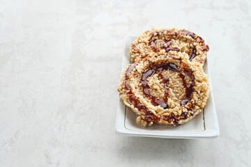 Rice crackers (intip madu or rengginang) with brown sugar on white background. Savory, sweet and crunchy.
