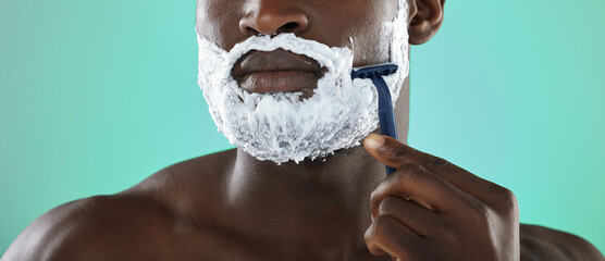 Black man, shaving and cream in studio for skincare, razor and facial cosmetics for beauty by blue background. African gen z model, hair removal foam or shave for aesthetic, cleaning or face grooming