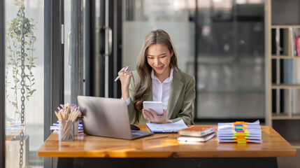 Everyday winner Excited Asian woman raising her arms while sitting at the desk in office, Happy excited employees work or business successful concept.