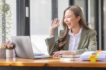 Everyday winner Excited Asian woman raising her arms while sitting at the desk in office, Happy excited employees work or business successful concept.