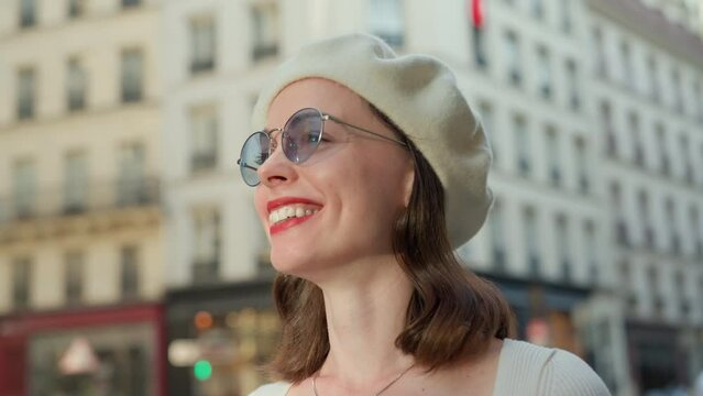 Smiling young woman in a white beret on the street in Paris