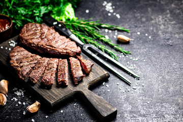 Steak grill on a cutting board with rosemary. 