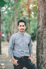 Man with beard and plaid shirt of aesthetic lumberjack in the middle of nature in portrait looking at camera