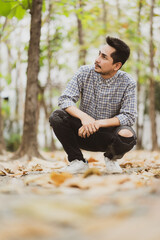 Man with beard and plaid shirt of aesthetic lumberjack in the middle of nature in portrait looking up