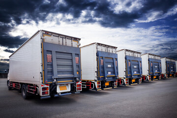 Cargo Container Trucks on The Parking Lot with Sunset Sky. Lifting Ramp Trucks. Commercial Transport Lorry. Shipping Delivery Trucks. Distribution Warehouse. Freight Truck Logistics Cargo Transport 