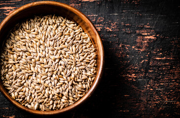 Grain in a wooden bowl on the table. 