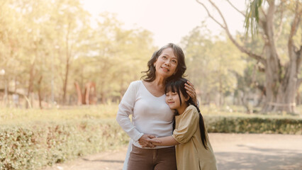 Fototapeta premium Portrait of asia grandmother and grandchildren holiday vacation together in the park in the summer in Southeast Asia Pacific.