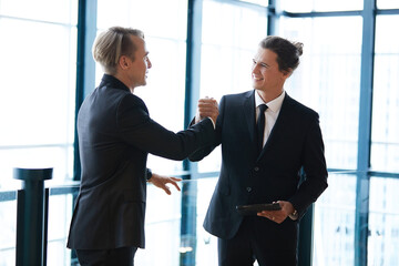 businessman shaking hands with friends and having fun in the office
