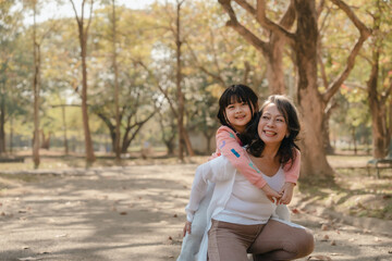 Fototapeta premium Portrait of asia grandmother and grandchildren holiday vacation together in the park in the summer in Southeast Asia Pacific. Hugging