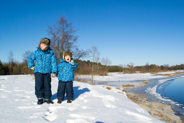 Fototapeta na wymiar Brothers in the winter by the river.