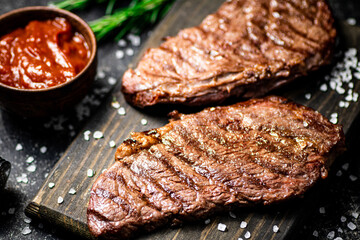 Grill steak on a wooden cutting board.