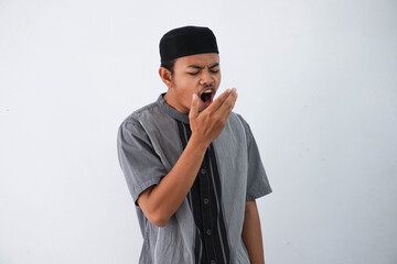 young Asian muslim man having bad breath problem during fasting in ramadan moth wearing grey muslim...