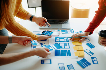  UX developer and ui designer brainstorming about mobile app interface wireframe design with...