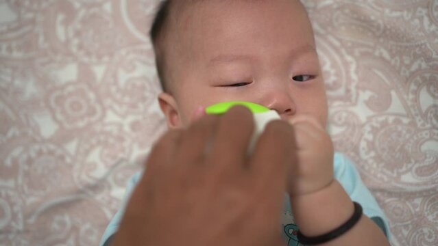 POV father hand give teether toy to cute crying baby